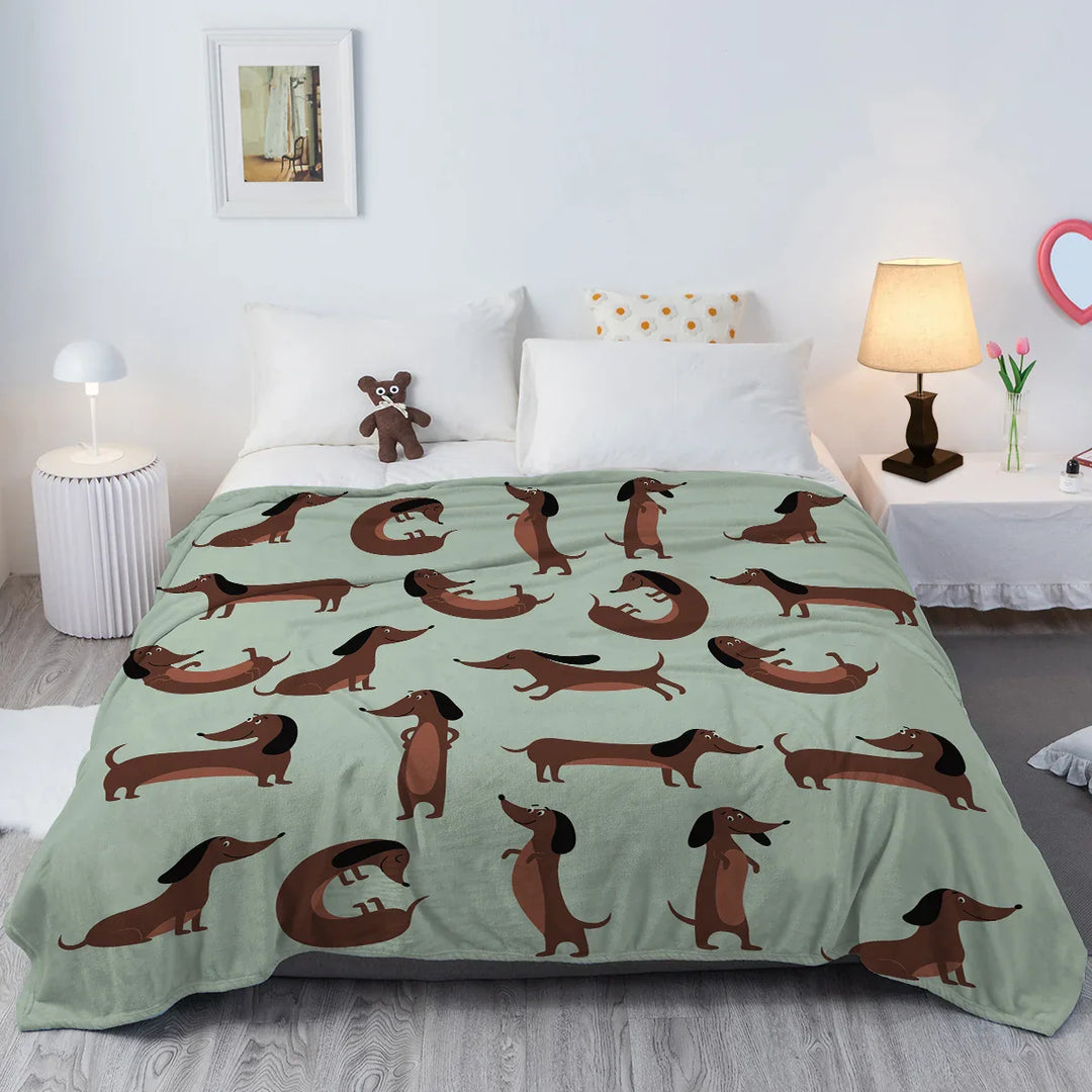 Kuschelige hellgrüne Dackel Fleece-Decke auf einem Sofa, perfekt für Hundeliebhaber und gemütliche Abende.