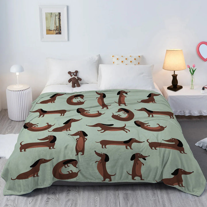 Kuschelige hellgrüne Dackel Fleece-Decke auf einem Sofa, perfekt für Hundeliebhaber und gemütliche Abende.