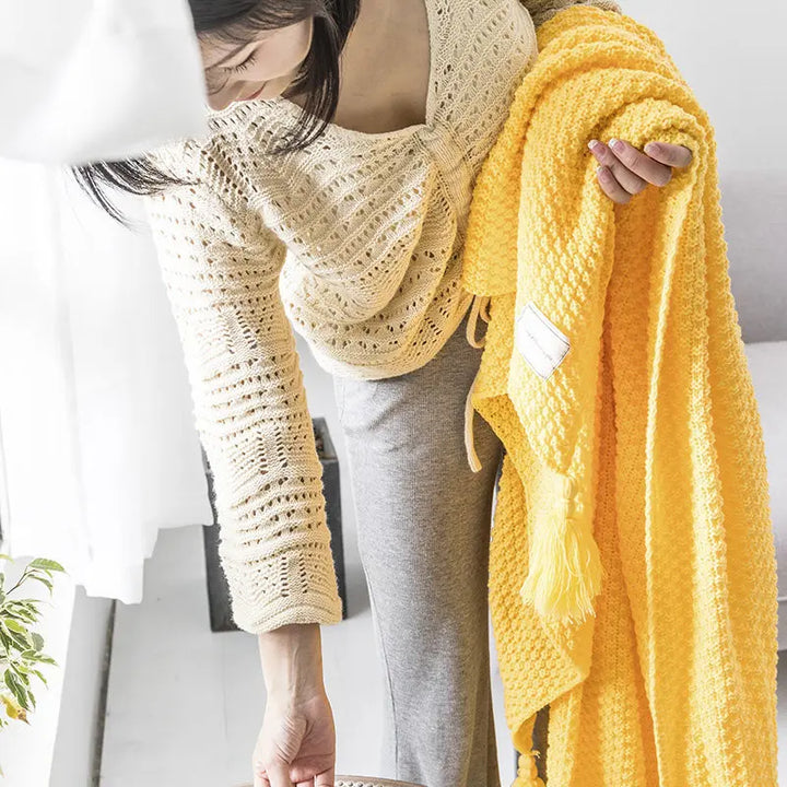 Schicke Wolldecke mit Quasten, eine gemütliche Heimtextilie, die Wärme und Stil ins Wohnzimmer bringt.