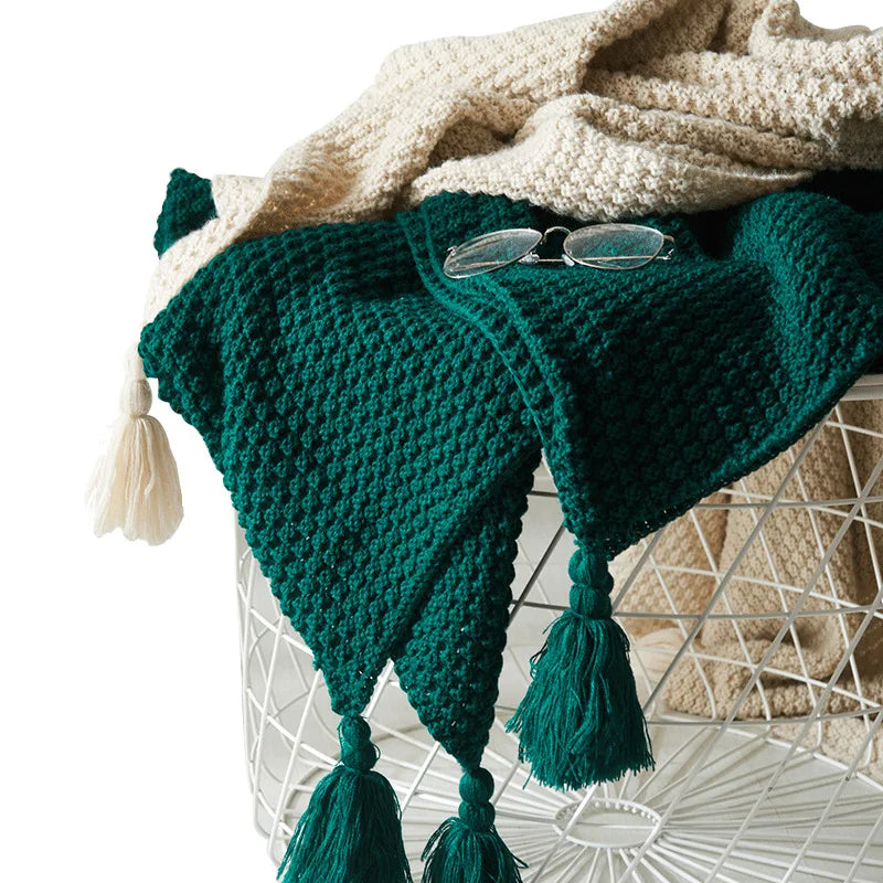 Stilvolle Strickdecke aus Wolle mit Quasten, perfekt als Deko für Sofa oder Bett im Winter.