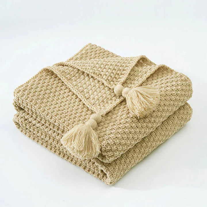 Warme Strickdecke aus Wolle für den Winter, mit eleganten Quasten als stilvolle Dekoration.