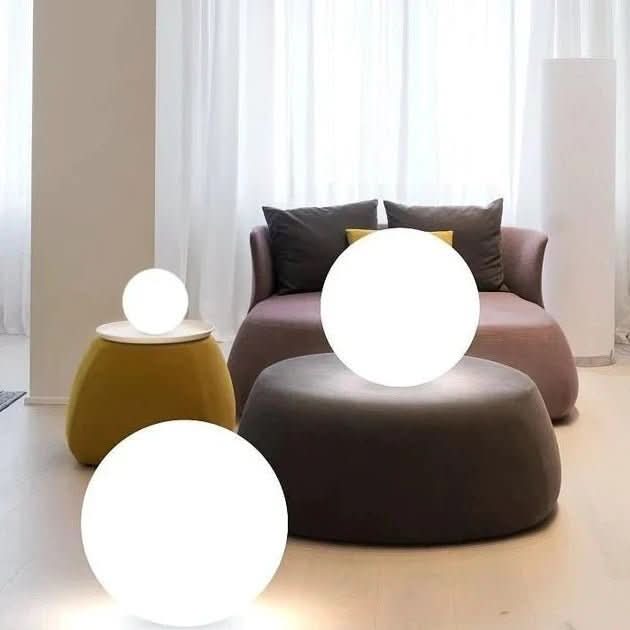 Leuchtende LED Dekokugel im Garten bei Nacht, erzeugt stimmungsvolles Farbwechsel-Licht.