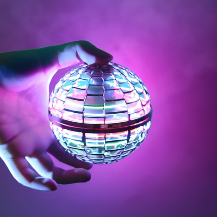 Kind spielt lachend mit dem interaktiven Fliegenden Orb Ball und seinen bunten LED-Lichtern. Tolles Outdoor-Spielzeug.