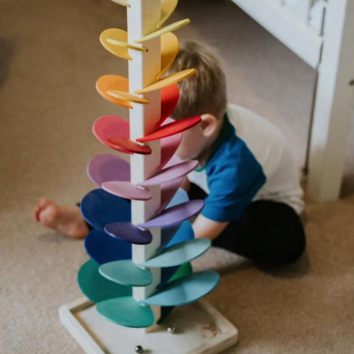 Interaktiver Luca Klangbaum mit Regenbogen-Murmelturm. Beobachte die Kugeln & genieße die beruhigenden Geräusche.