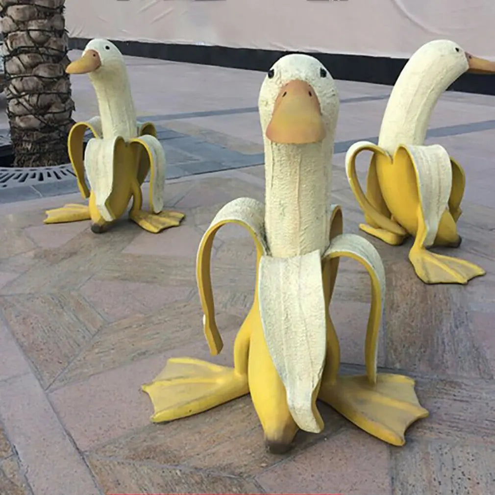Lustige Bananenente "Quaki" Gartendeko aus wetterfestem Kunstharz für verspielte Außendekoration.