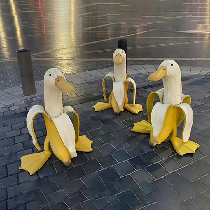 Nahaufnahme der detaillierten Bananenente "Quaki" Skulptur aus Kunstharz, zeigt lustige Füße und Entengesicht.