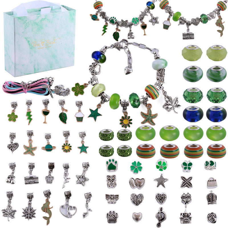 Nahaufnahme eines Mädchens, das eine Perle auf ein Charm Armband fädelt.