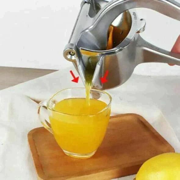 Manuelle Edelstahl Zitruspresse beim Entsaften einer halben Orange. Küchenhelfer für frischen Saft mit Hebelmechanismus.