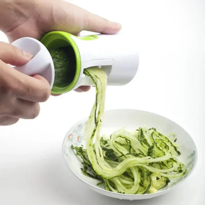 Manueller Gemüseschneider in Aktion, der frische Zucchini zu langen Zoodles verarbeitet. Ideal für Low-Carb.