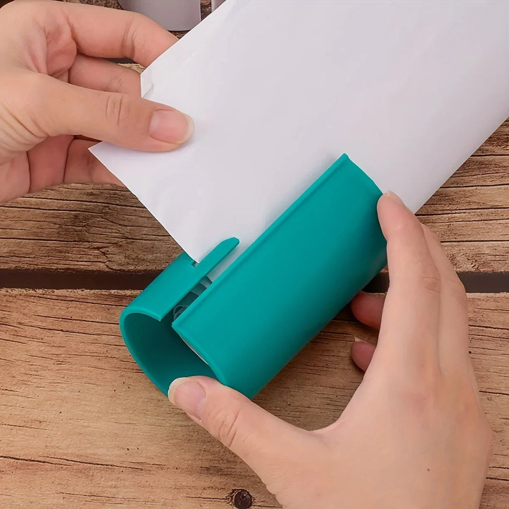 Kompakter Papierschneider mit geschützter Klinge, ideal für sicheres Basteln und Geschenkverpackungen.