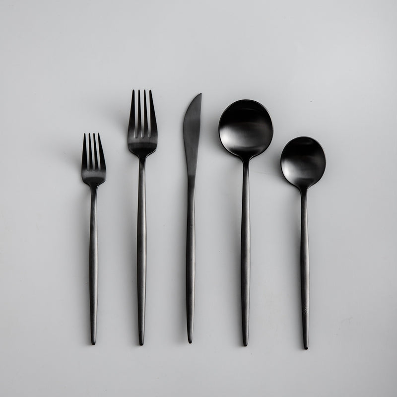 Luxuriöses matt-goldenes Essbesteck, elegant gestapelt. Ideal für moderne, stilvolle Küchen.