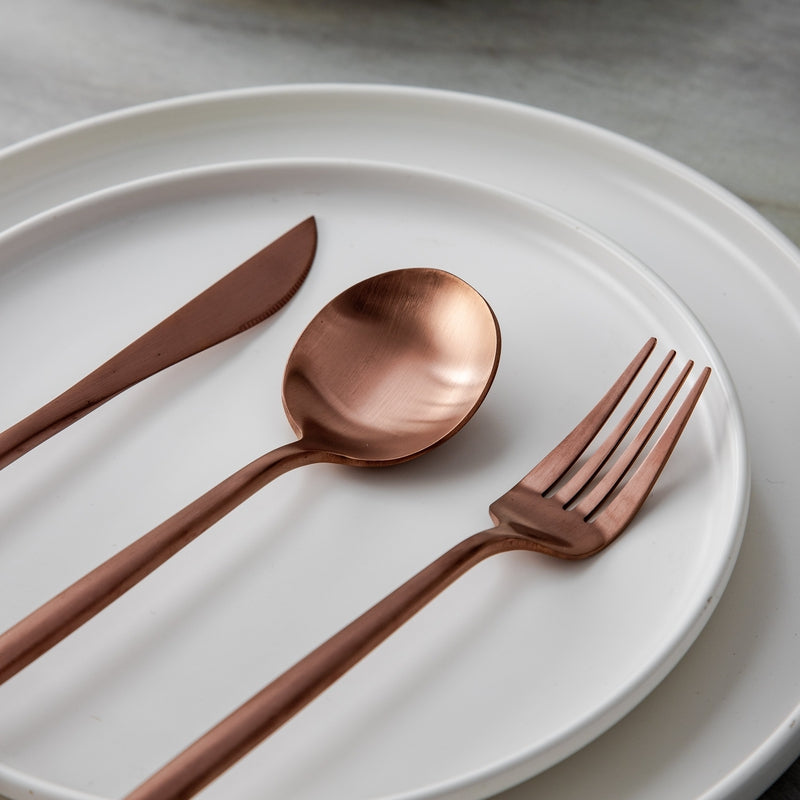 Roségoldener Teelöffel mit mattem Finish neben einer modernen Kaffeetasse. Für minimalistische Küchen.