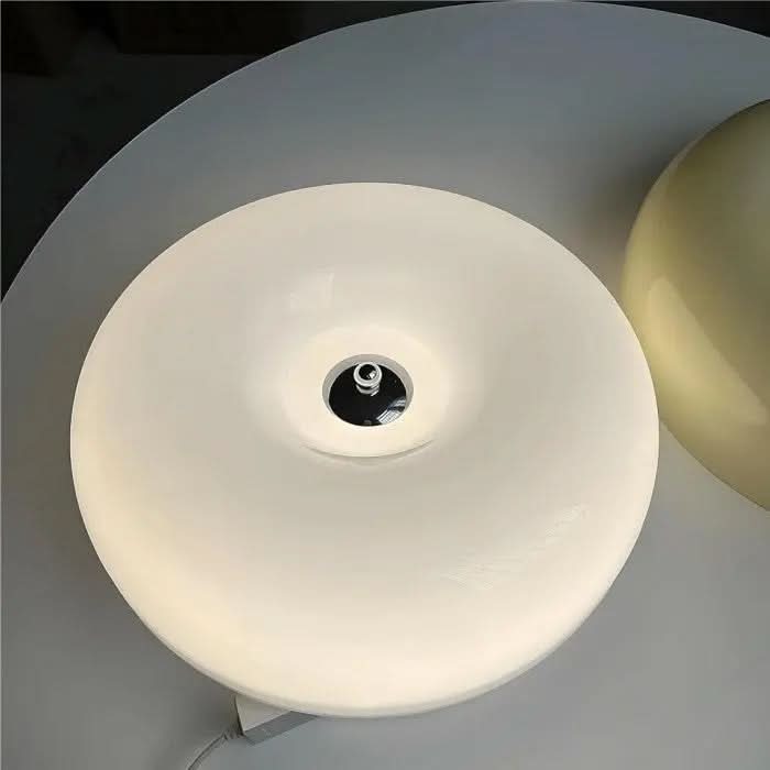 Eine moderne LED-Donut-Lampe, stilvoll auf einem Nachttisch platziert, als stimmungsvolles Schlafzimmerlicht.