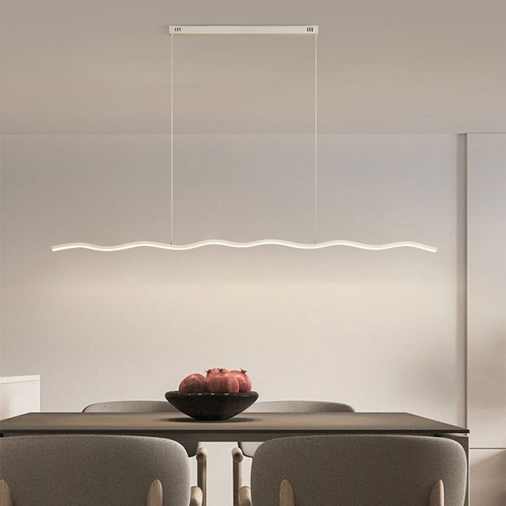 Dimmbare LED-Pendelleuchte WaveGlow, wellenförmig, schafft warmes Licht im Esszimmer oder Wohnzimmer.