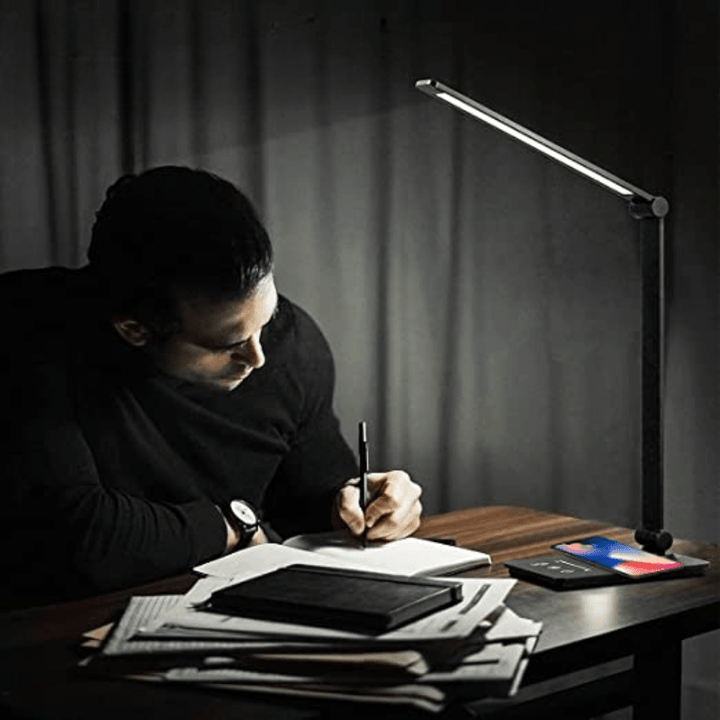 Augenfreundliche LED-Schreibtischlampe, Helligkeit anpassbar, mit Qi-Ladefunktion für komfortables Arbeiten.