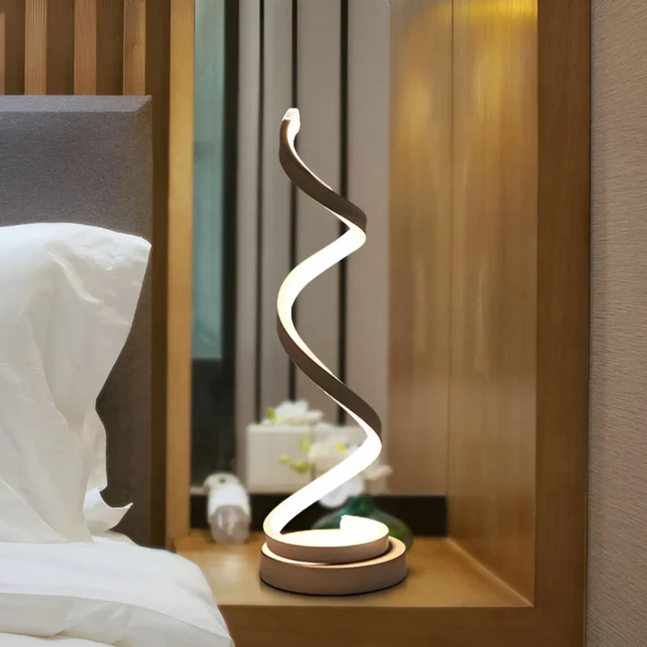 Dimmbare LumaSpiral LED-Tischlampe mit einzigartiger Spiralform, schafft behagliche Atmosphäre im Schlafzimmer.