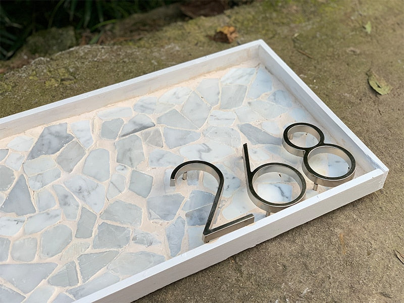 Silberne Hausnummer "33" in minimalistischem Design, perfekt für eine moderne Hausfassade.