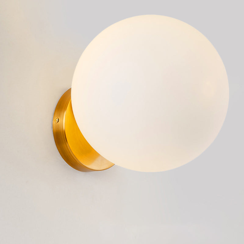 Moderne Wandleuchte mit mattem Lichtkugel und elegantem Sockel in Gold-Optik für stilvolle Innenbeleuchtung.