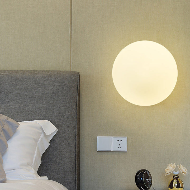 Wandleuchte mit goldener Basis und mattem Lichtkugel, ideal für moderne Beleuchtung im Innenbereich.