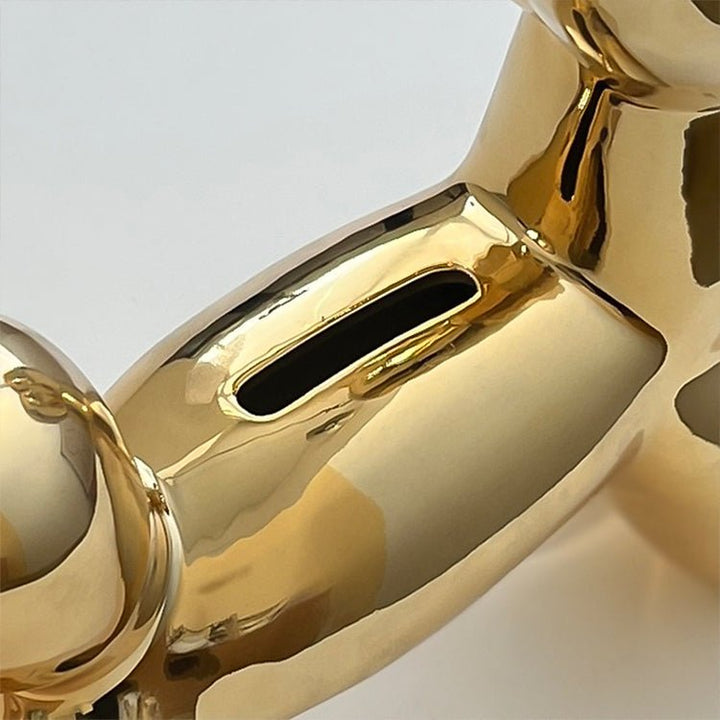 Luxuriöses goldenes Ballonhund Sparschwein als moderne Dekoskulptur. Perfektes Geschenk und stilvolles Wohnaccessoire.