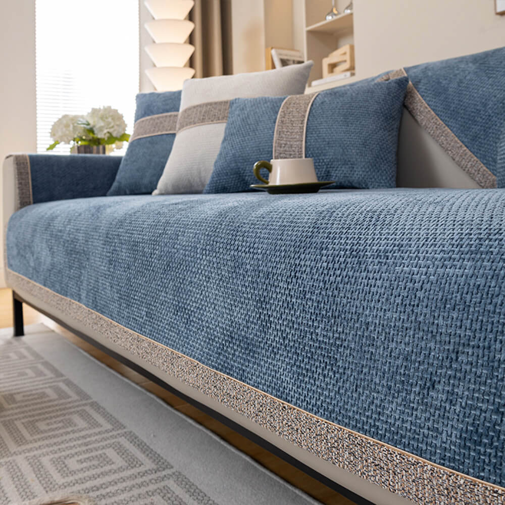 Eng anliegender, moderner Sofaschutzbezug in Schwarz, betont die Form des Sofas und verhindert Verrutschen.