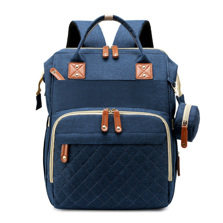Eltern wickeln Baby auf dem ausklappbaren Wickelbett des praktischen Wickelrucksacks unterwegs.