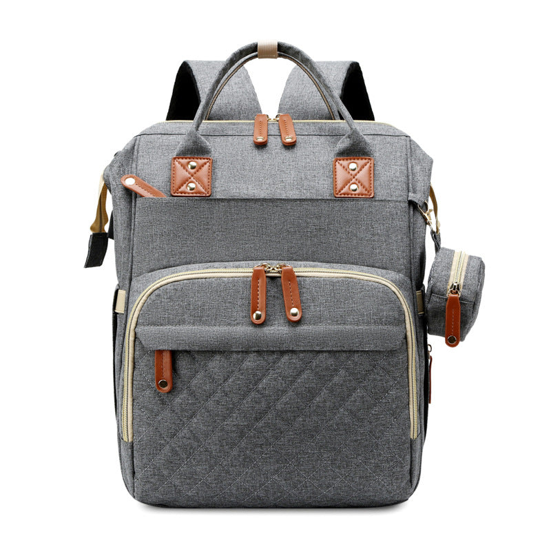 Der multifunktionale Babyrucksack von der Seite zeigt seine kompakte Form und das erweiterbare Wickelbett.