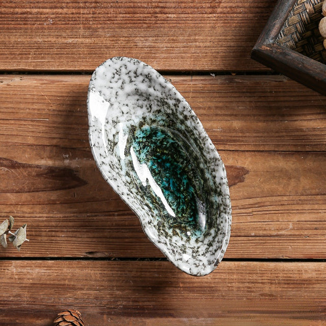Elegante muschelförmige Keramikplatte, ideal als Geschirr oder Deko für japanische Speisen.