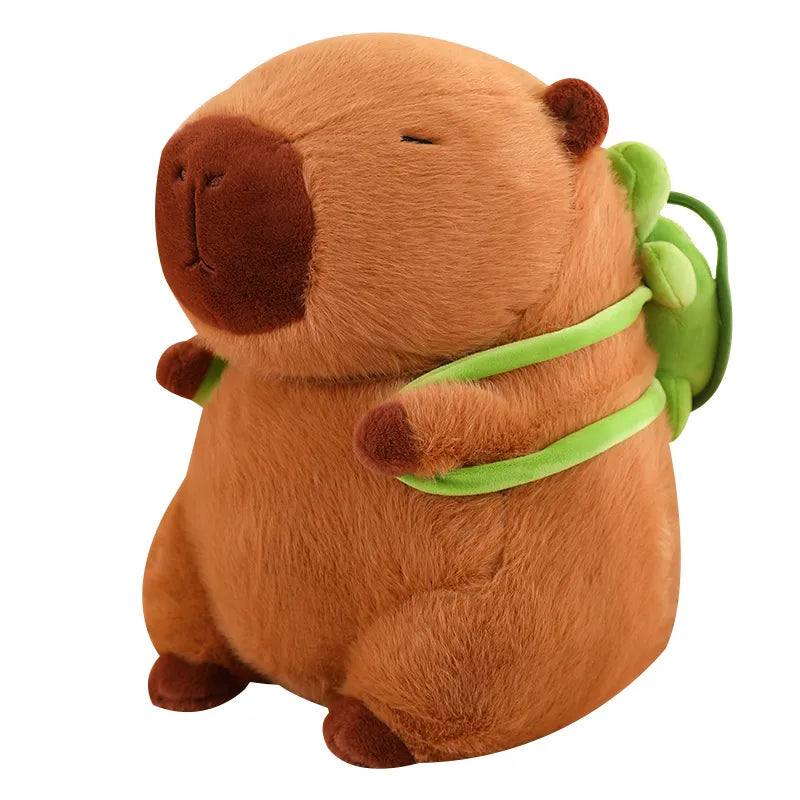 Niedliches braunes Capybara Kuscheltier mit kleinem grünem Schildkröten-Rucksack für Kinder.