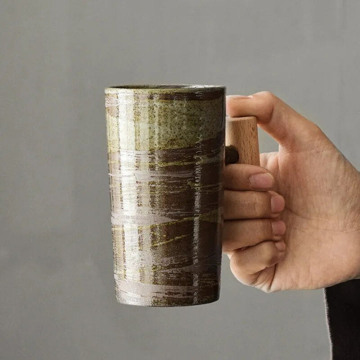Handgefertigte Keramiktasse mit stabilem Holzgriff im nordischen Naturdesign. Erdige Farben, ideal als Kaffeetasse.
