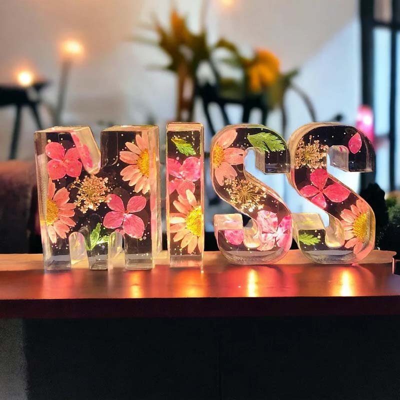 Gemütliches LED-Nachtlicht, Buchstabenlampe mit zarten Harzblumen, schafft warme Schlafzimmeratmosphäre.
