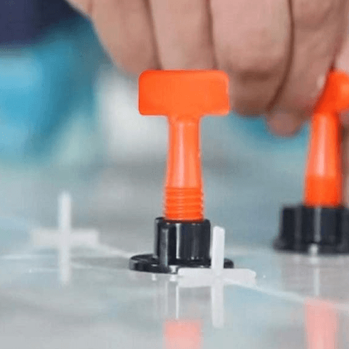 Wiederverwendbares Fliesen-Nivelliersystem mit T-Nadeln und Clips für präzise, schnelle Fliesenverlegung.