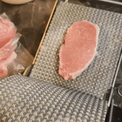 Eine ergonomische Fleischpresse aus Edelstahl für komfortables Formen von Schnitzeln und Burgern.