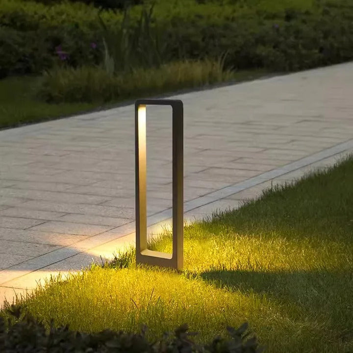 Installierte Outdoor LED-Bodenlampe beleuchtet einen Gartenweg, moderne und robuste Außenleuchte.