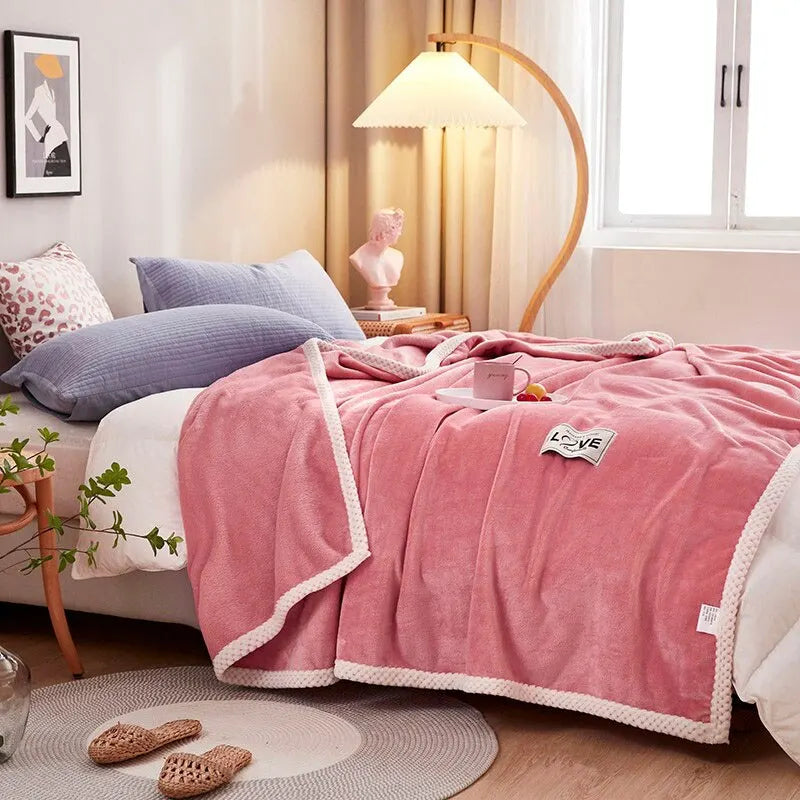 Rosa Flanell-Fleece-Decke auf Sofa für gemütliche Abende. Warme Kuscheldecke für Wohnzimmer & Schlafzimmer.