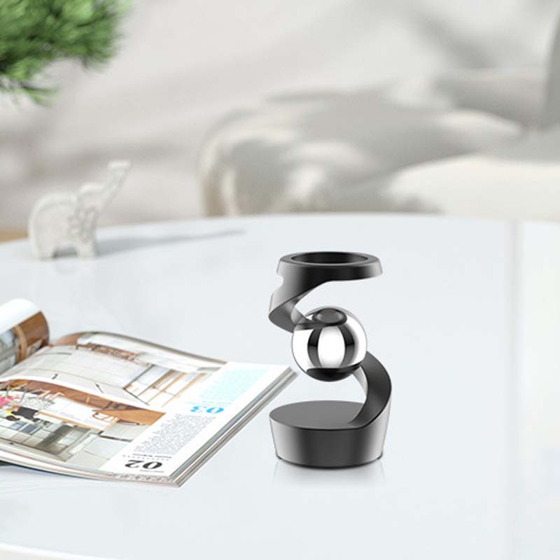 Modernes Desktop-Gyroskop auf dunklem Holzschreibtisch, beruhigend, inspirierend & konzentrationsfördernd.