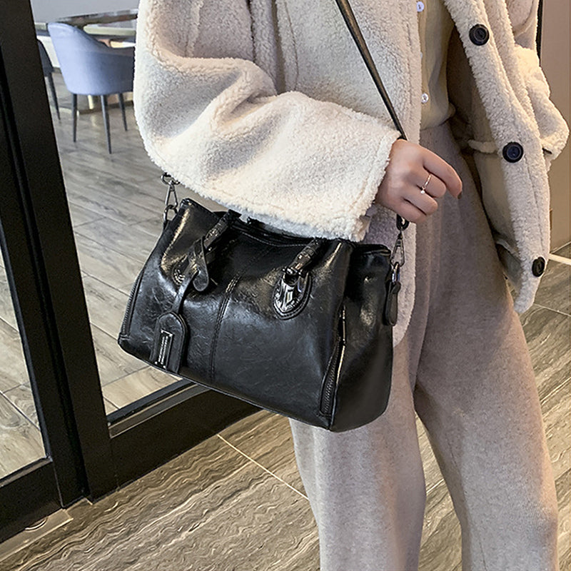 Nahaufnahme des weichen Ölwachsleders der roten Boston Damen Umhängetasche. Hochwertige Retro-Handtasche.