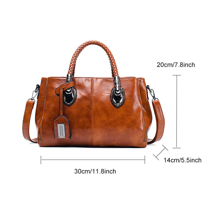 Rote Boston Umhängetasche aus Ölwachsleder auf Bank. Große, weiche Leder-Damenhandtasche für Freizeit.