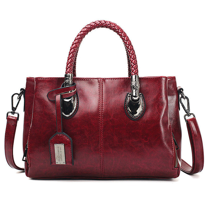 Braune Damen Boston Umhängetasche, präsentiert mit elegantem Griff. Weiche, große Leder-Umhängetasche.