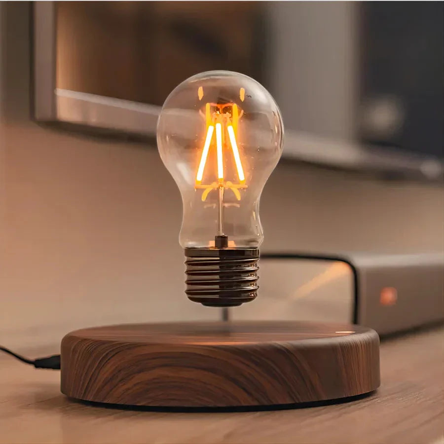 Design LED Tischlampe mit schwebender Glühbirne auf Walnussholz-Sockel. Kreative Dekolampe für Wohn- und Büroräume.