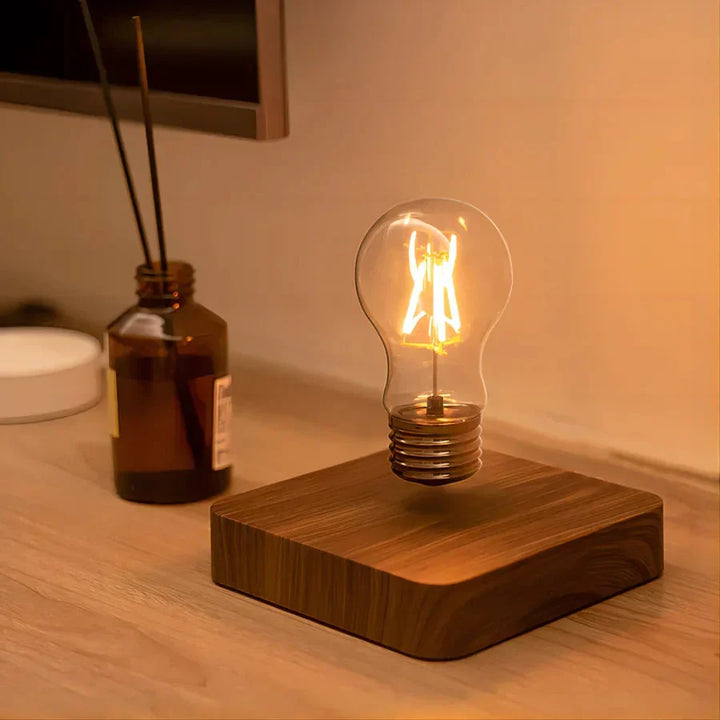 Einzigartige schwebende Glühbirne als moderne LED Dekolampe. Walnussholz-Sockel fügt sich elegant in jedes Interieur ein.
