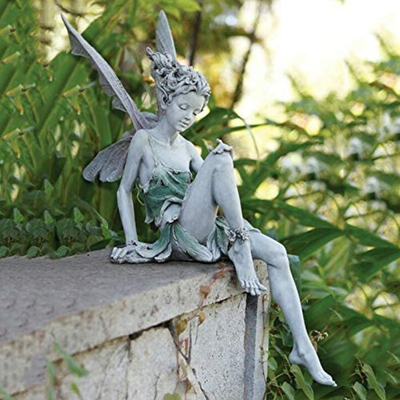 Nahaufnahme der sitzenden Fee Gartenfigur mit filigranen Flügeln und anmutigem Gesichtsausdruck.