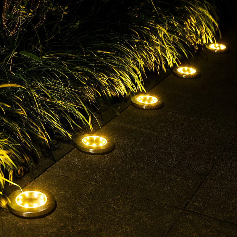 Eine Gruppe EcoGlow Solar-Gartenleuchten schafft stimmungsvolle Atmosphäre im Außenbereich.
