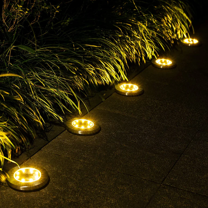 Eine Gruppe EcoGlow Solar-Gartenleuchten schafft stimmungsvolle Atmosphäre im Außenbereich.
