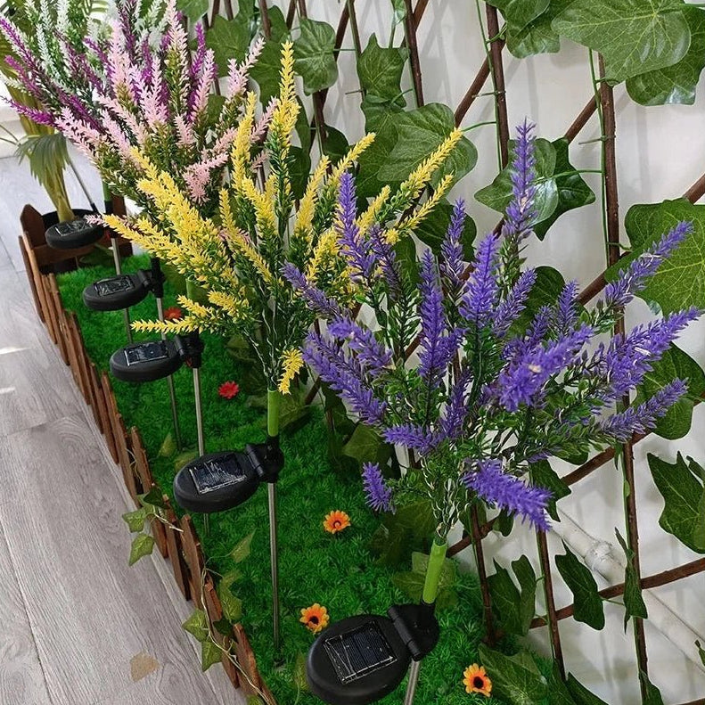 Wetterfeste Solarlampe mit Lavendeldesign lädt tagsüber Energie für die Nachtbeleuchtung im Garten.