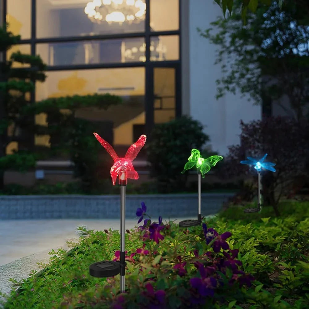 Nahaufnahme Solare LED-Gartenlampe Kolibri, leuchtend bei Nacht; stimmungsvolle Gartendeko.