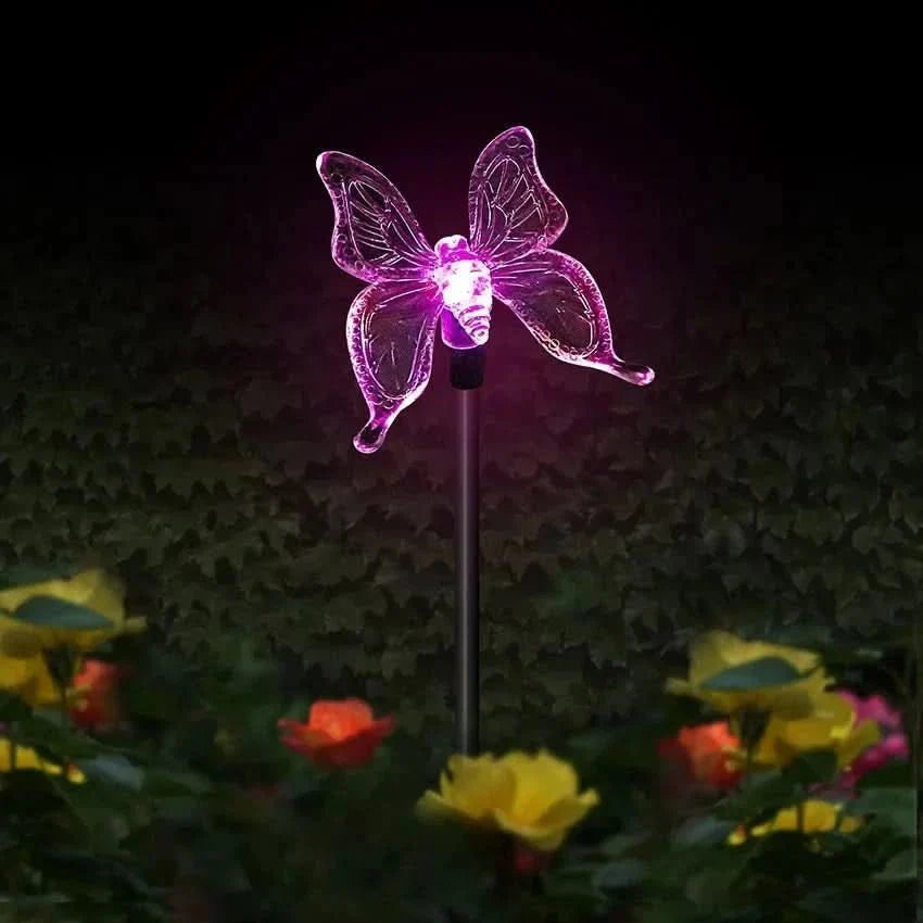 Verschiedene Solarlampen: LED-Gartenlampe Schmetterling, Kolibri, Libelle im Blumenbeet.