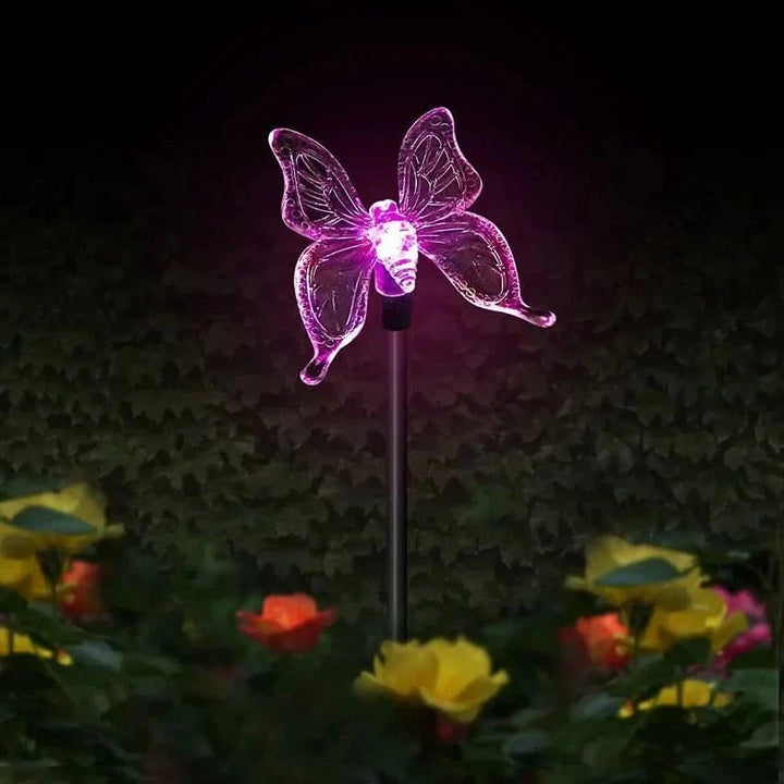 Verschiedene Solarlampen: LED-Gartenlampe Schmetterling, Kolibri, Libelle im Blumenbeet.