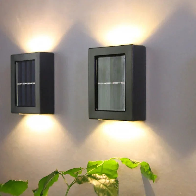 Zwei solarbetriebene Wandlampen beleuchten den Gartenweg, kabellos und einfach zu installieren.