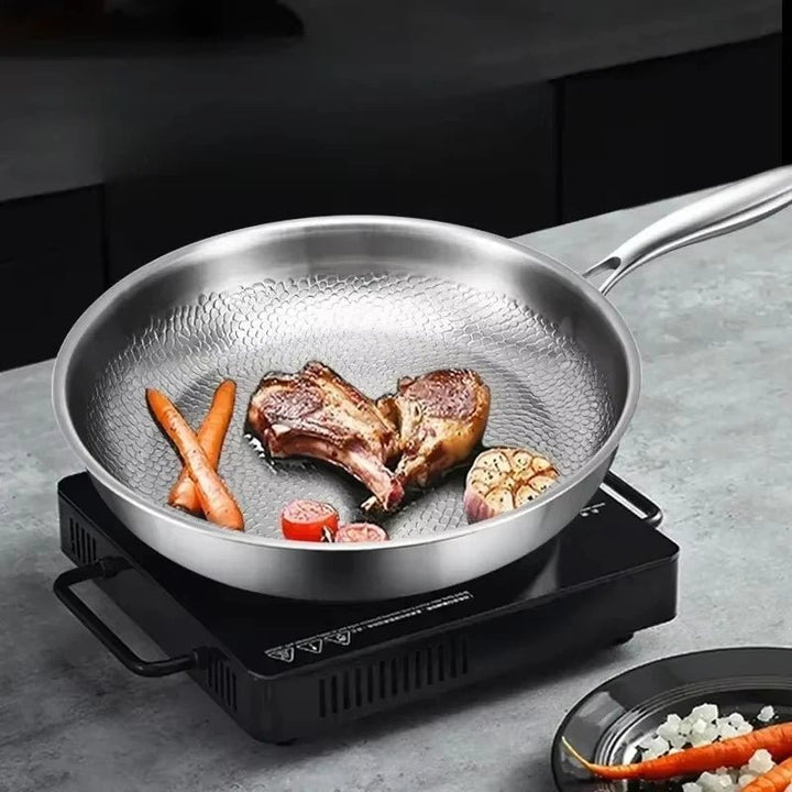 Induktionsgeeignete Antihaft-Bratpfanne aus Titan mit gehämmerter Oberfläche, ideal für moderne Küchen.